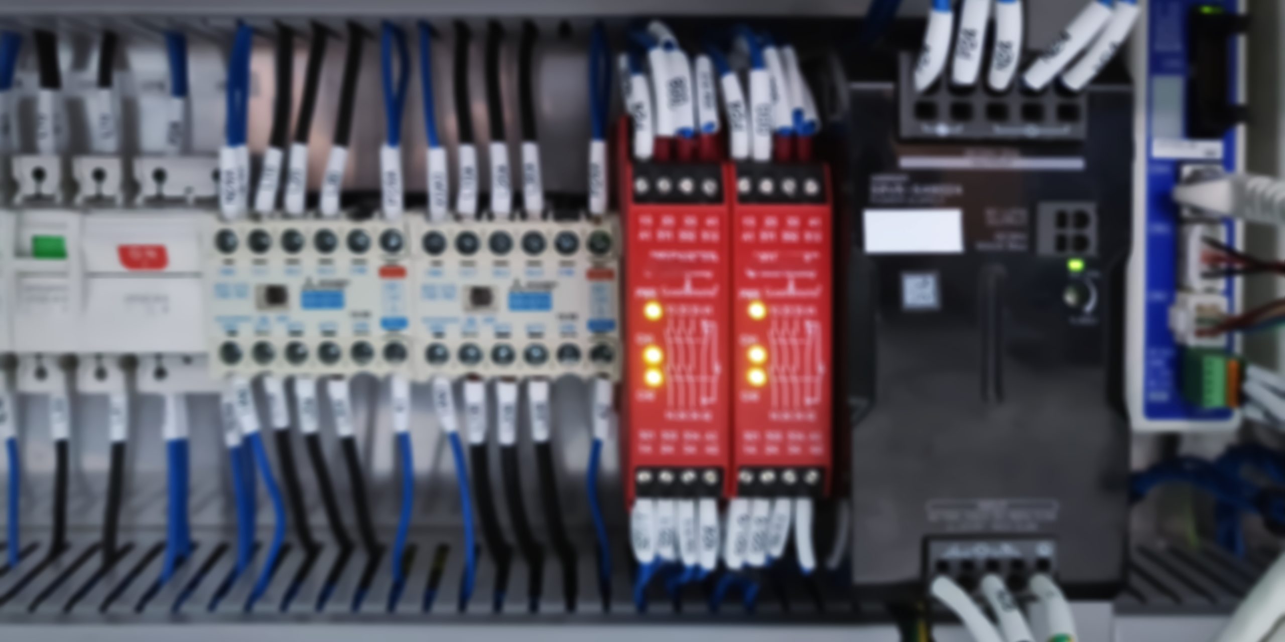 Blurred Background of Switches and Wiring Inside of Electrical Control Cabinet Sicherheitsrelais in einem Schaltschrank